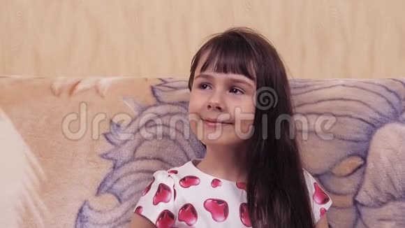 孩子的情绪在沙发上穿着漂亮裙子的小女孩穿着红心衣服的女孩视频的预览图