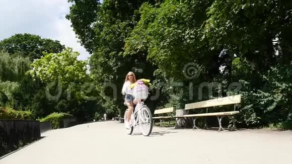 晴天女孩在城市公园骑自行车视频的预览图