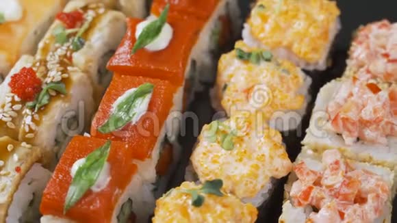 寿司卷在黑色背景上旋转寿司日本料理餐厅日本餐厅菜单4UHD视频视频的预览图