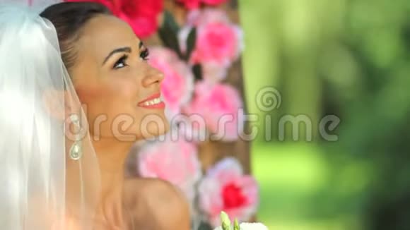 快乐新娘的肖像一位戴着面纱的美丽新娘正拿着一束花背景是视频的预览图