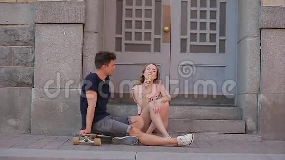 年轻的一对恋爱中的情侣坐在纳夫斯基的门槛上在懒洋洋地交谈视频的预览图