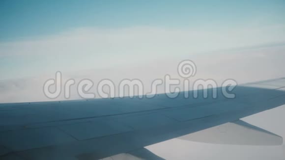从飞机的窗口观看天空和云彩乘飞机旅行的概念飞机机翼的近景视频的预览图