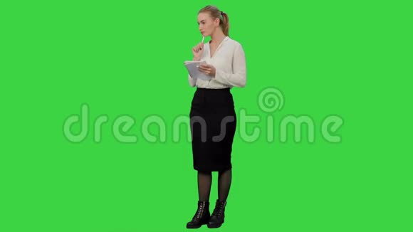 有吸引力的商务女性做一些计算并将它们写在绿色屏幕上的纸上铬键视频的预览图