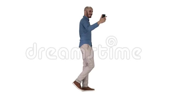 快乐微笑英俊的年轻人在白色背景上行走时自拍视频的预览图