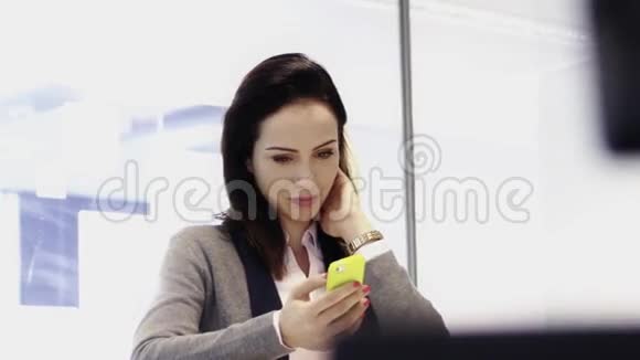女商人在繁忙的办公室里使用手机视频的预览图