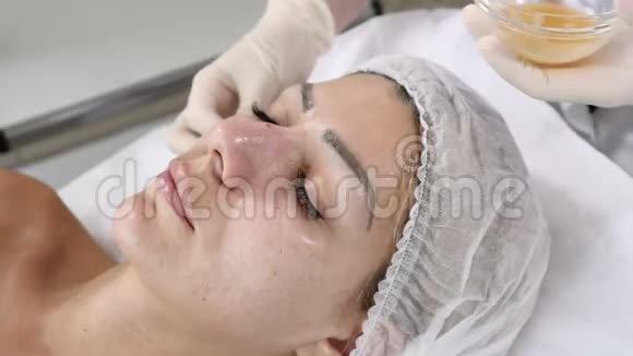 美的概念年轻女性客户获得美容面部手术面部翻新美容师用棉芽覆盖视频的预览图