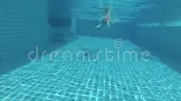 快乐美丽迷人的年轻女子在游泳池水下观景操作摄像机视频的预览图