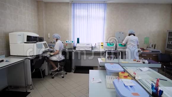 妇女实验室的技术人员穿着白大褂在一家私人诊所对病人进行分析他们检查血液视频的预览图