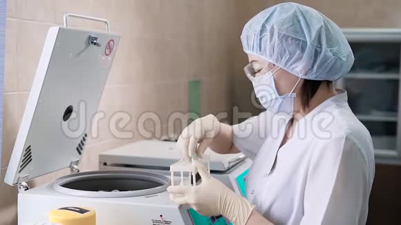 一名身穿白色长袍和手套的年轻女子近距离拍摄一名护士将带有血液的试管放入一个现代化的视频的预览图