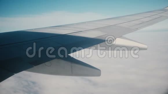 从飞机窗口到飞机机翼的视图在天空中飞过云层的车辆翅膀上的影子视频的预览图