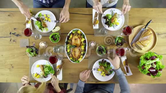 俯视图四位白种人朋友一起吃午餐喝酒烤面包和鸡肉沙拉土豆红色视频的预览图