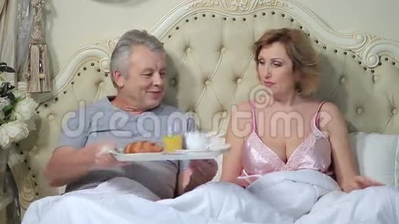 年长夫妇在床上享受早餐视频的预览图