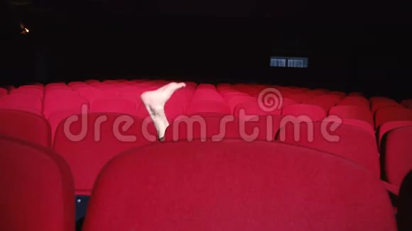 男在电影院大厅的一排排红椅子之间表演脚戏视频的预览图