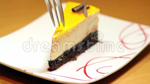 一个人开始在白色盘子里吃一个漂亮的橙色蛋糕的录像视频的预览图