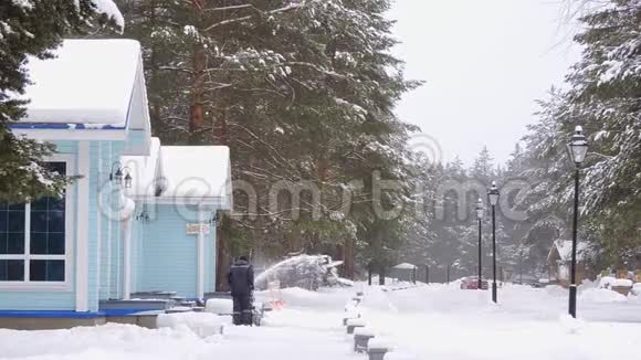 在冬季暴风雪中推雪人的工人视频的预览图