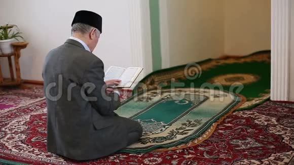 一位老毛拉手里拿着可兰经祈祷视频的预览图