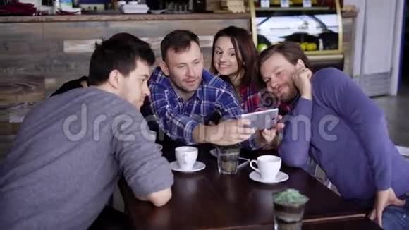 一群年轻的朋友坐在餐厅里互相交谈使用数字小工具三个帅哥视频的预览图