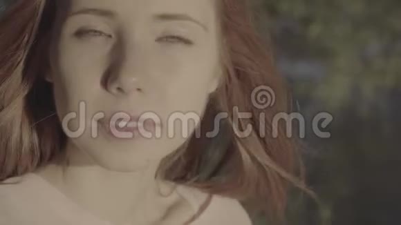 公园里一个漂亮的红发积极女孩的肖像彩色简介视频的预览图