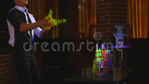 杂技表演由巴曼杂耍两个瓶子和烧杯进行混合酒吧背景视频的预览图