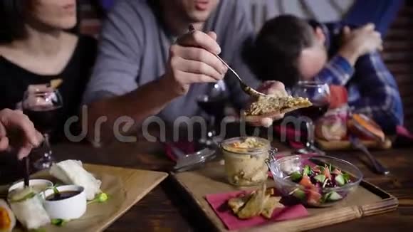 在餐馆里一个英俊的男人坐在餐桌旁用黄油铺面包吃美味的烤面包视频的预览图