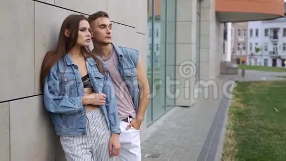 男人和女人穿着休闲的街头服装摆在灰色的墙前视频的预览图