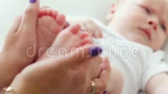 母亲抱着刚出生的婴儿的脚视频的预览图