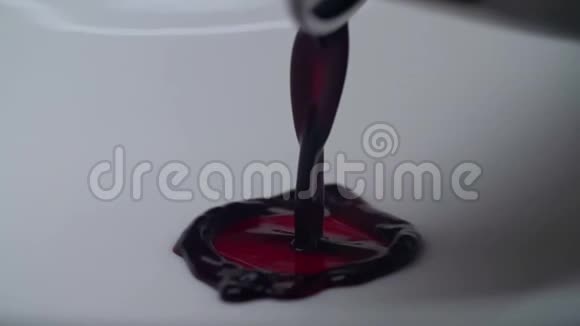 一股黑色的栗色油脂倒在白色光滑的表面上视频的预览图