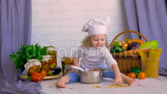 可爱的女孩厨师用蔬菜和平底锅烹饪健康的食物视频的预览图