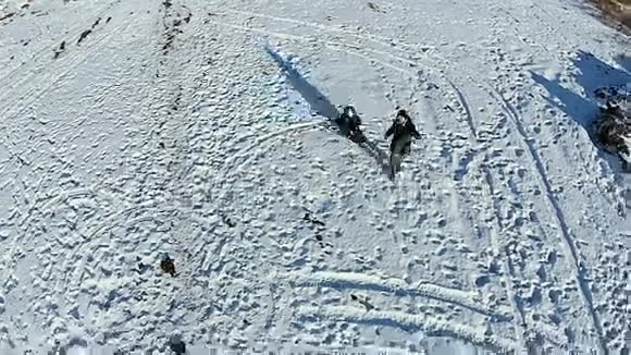 男人把孩子卷在雪橇上玩得开心视频的预览图