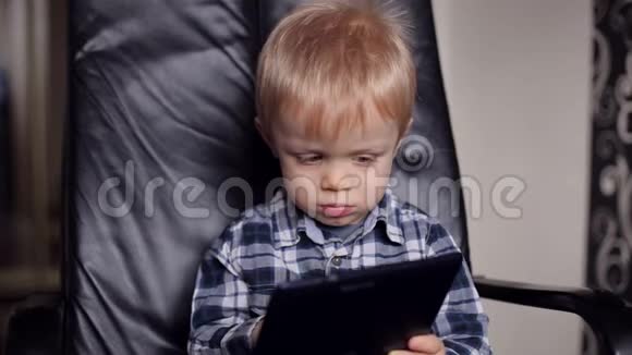 小男孩穿着带平板电脑的衬衫的肖像视频的预览图