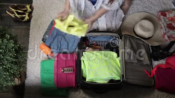 女性手把衣服装进旅行袋视频的预览图