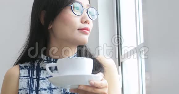 近距离观看女性手拿一个白色杯子与热咖啡从桌子上视频的预览图