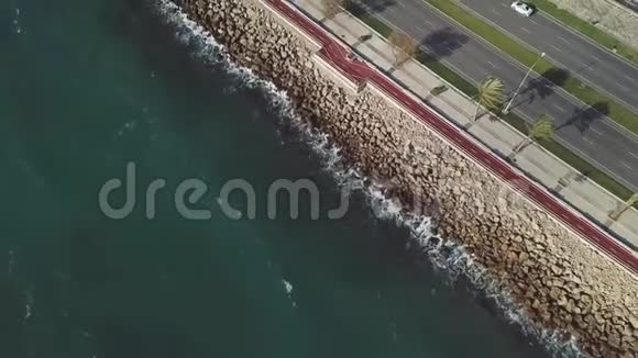 空中飞行在岩石海岸的高速公路上跟随汽车射击库存海岸线沿线和视频的预览图