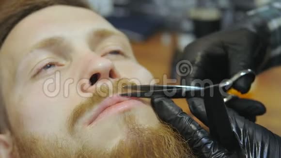 男士美容师理发店照顾胡子一个理发师在胡子和胡子上工作视频的预览图