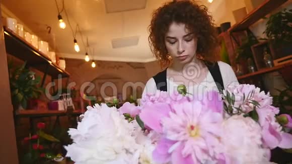 工作中的花商制作时尚现代花束的女人视频的预览图