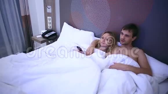 在床上看电视的年轻夫妇睡着了视频的预览图