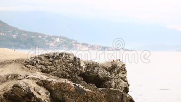 一个背着背包的女旅行者站在海上的岩石上视频的预览图