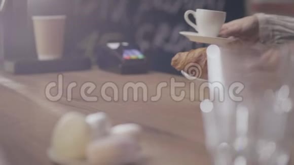 在咖啡馆的酒吧买一个羊角面包和咖啡视频的预览图