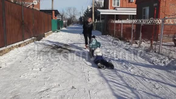 冬天年轻妇女和儿童在玩雪橇视频的预览图