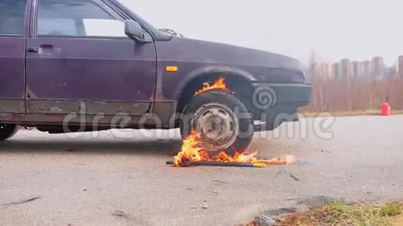寒冷的日子里旧的紫罗兰色的汽车被遗弃在尘土飞扬的道路上车轮燃烧着视频的预览图