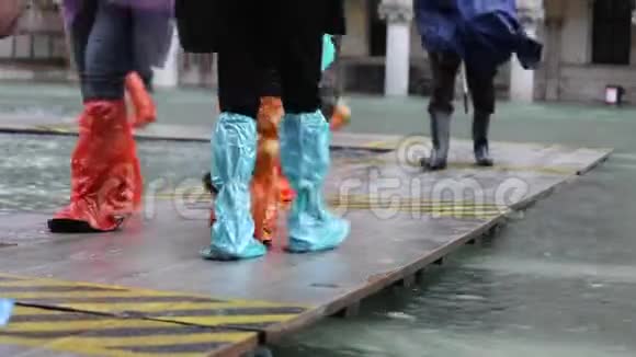 在威尼斯的洪水中人们在人行道上行走视频的预览图