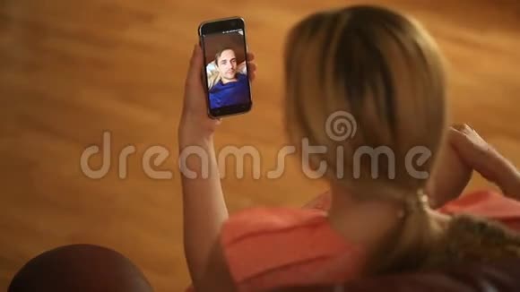 一个女人在智能手机上和一个男人举行视频聊天他们谈笑风生视频的预览图