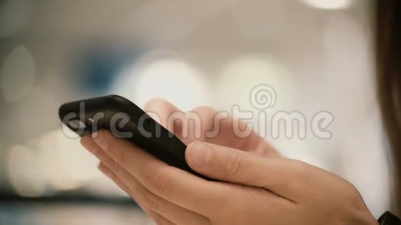 近距离观看女性手握智能手机采用触摸屏技术年轻女子在屏幕上打字视频的预览图