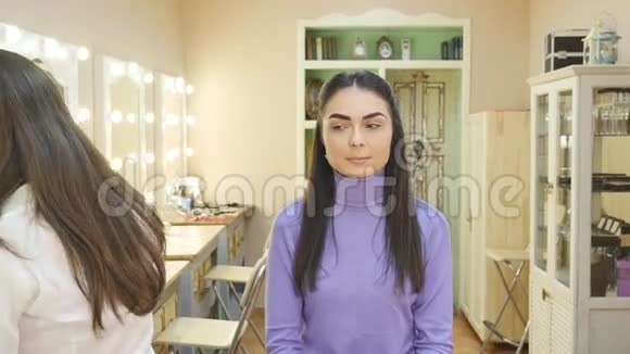 化妆师在模特的脸颊上用刷子涂粉视频的预览图