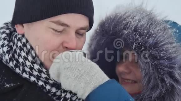年轻的爱人在冬天的公园里取暖视频的预览图