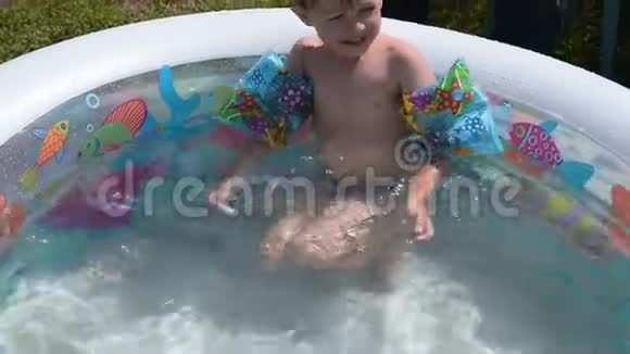 小男孩在自己的游泳池里享受夏日沐浴视频的预览图