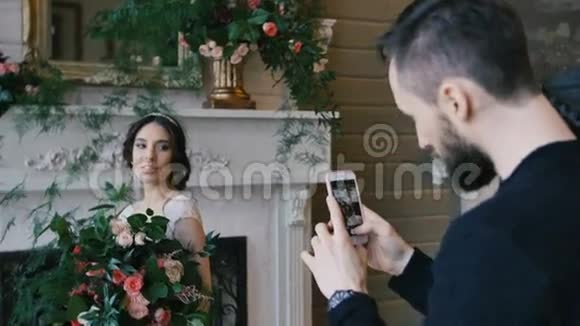 摄影师用手机拍摄新娘花束背景上的壁炉视频的预览图