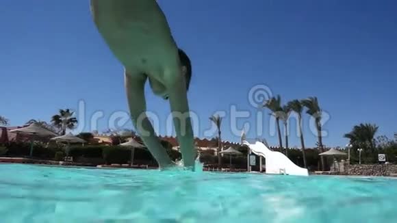 男孩在游泳池里跳水下慢动作视频的预览图