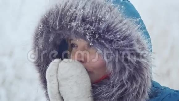 一个穿着手套的好女孩在冬天的公园里喝热茶取暖视频的预览图