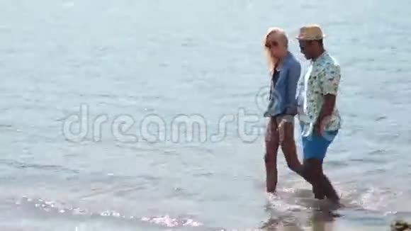 一对手牵着手在沙滩上漫步视频的预览图